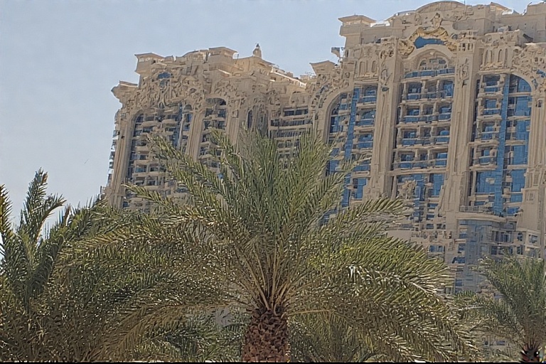 Luxurious facade of Emirates Palace hotel with palm trees in the foreground